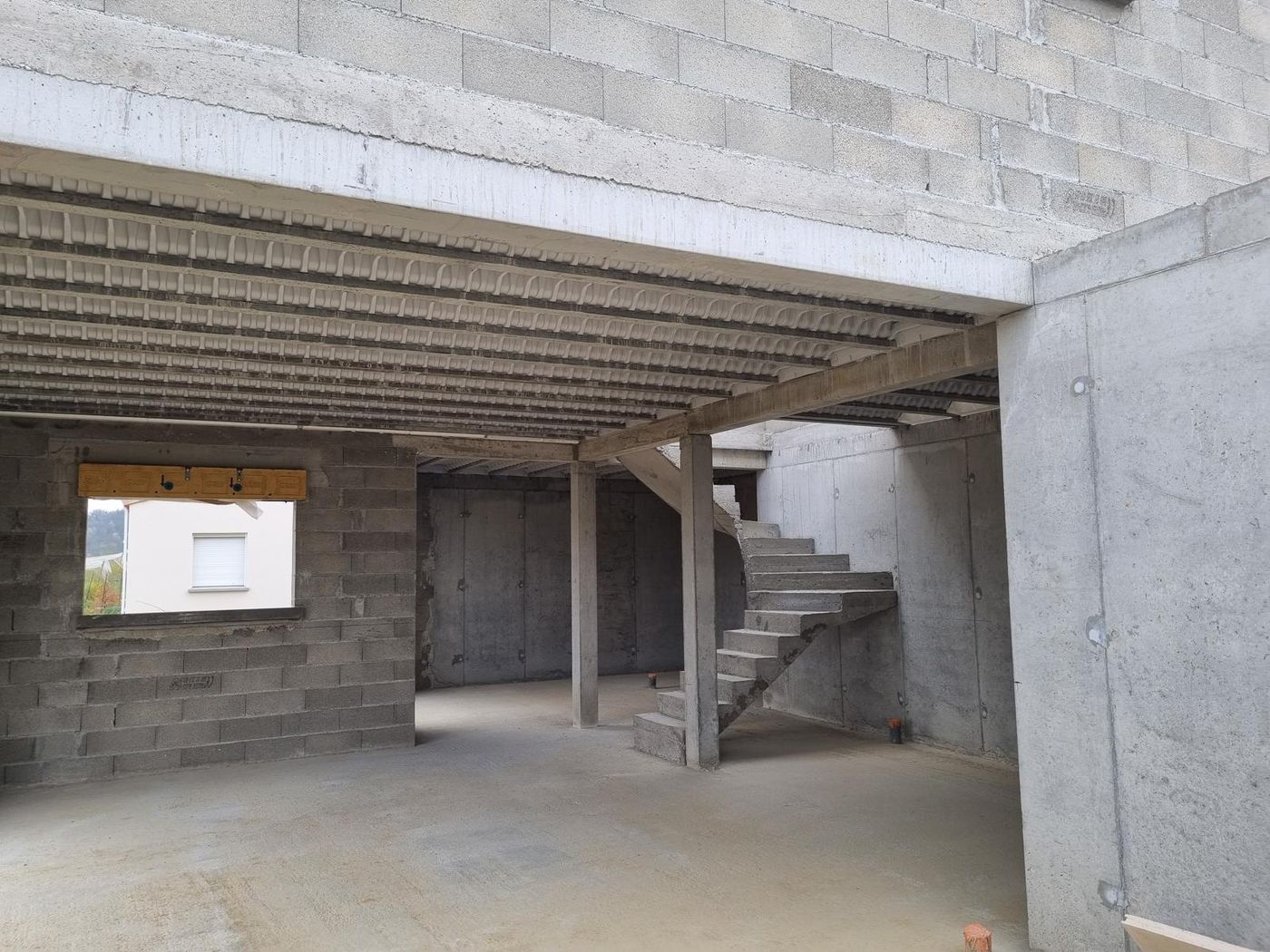 Sous-sol terminé avec son plancher poutrelles-hourdis, son poteau béton et son escalier coulé en place