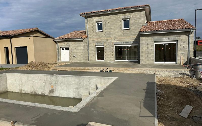 Dalle béton et bassin réalisés autour d'une maison neuve par SM BAT